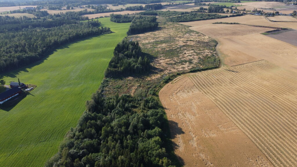 En luftfoto av en gård og jorder som viser vakker vegetasjon.