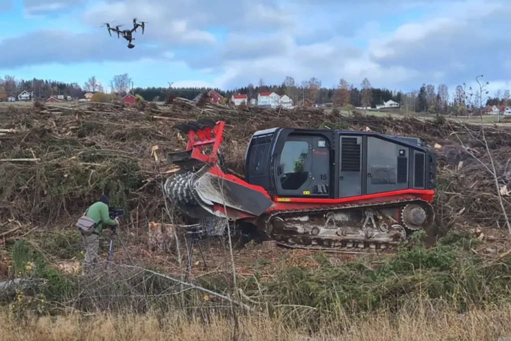 En rød bulldoser i en åsside med en drone i bakgrunnen utfører reb anlegg, park og anlegg oppgaver.